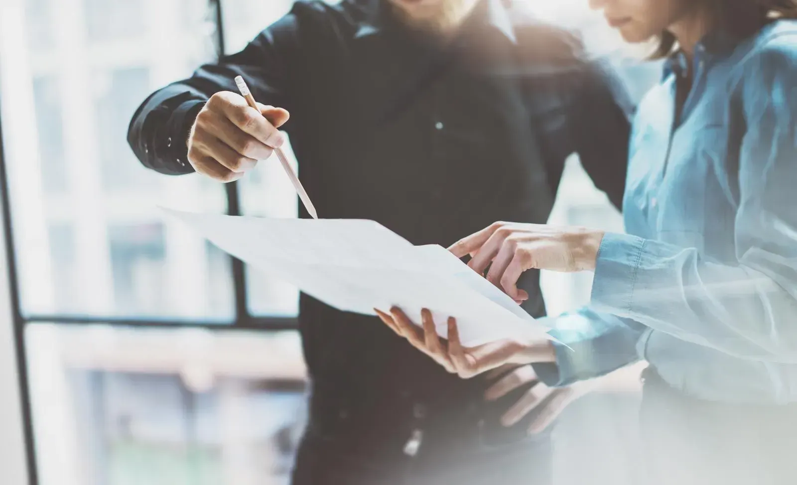 Ein Mann und eine Frau schauen auf ein Blatt Papier.