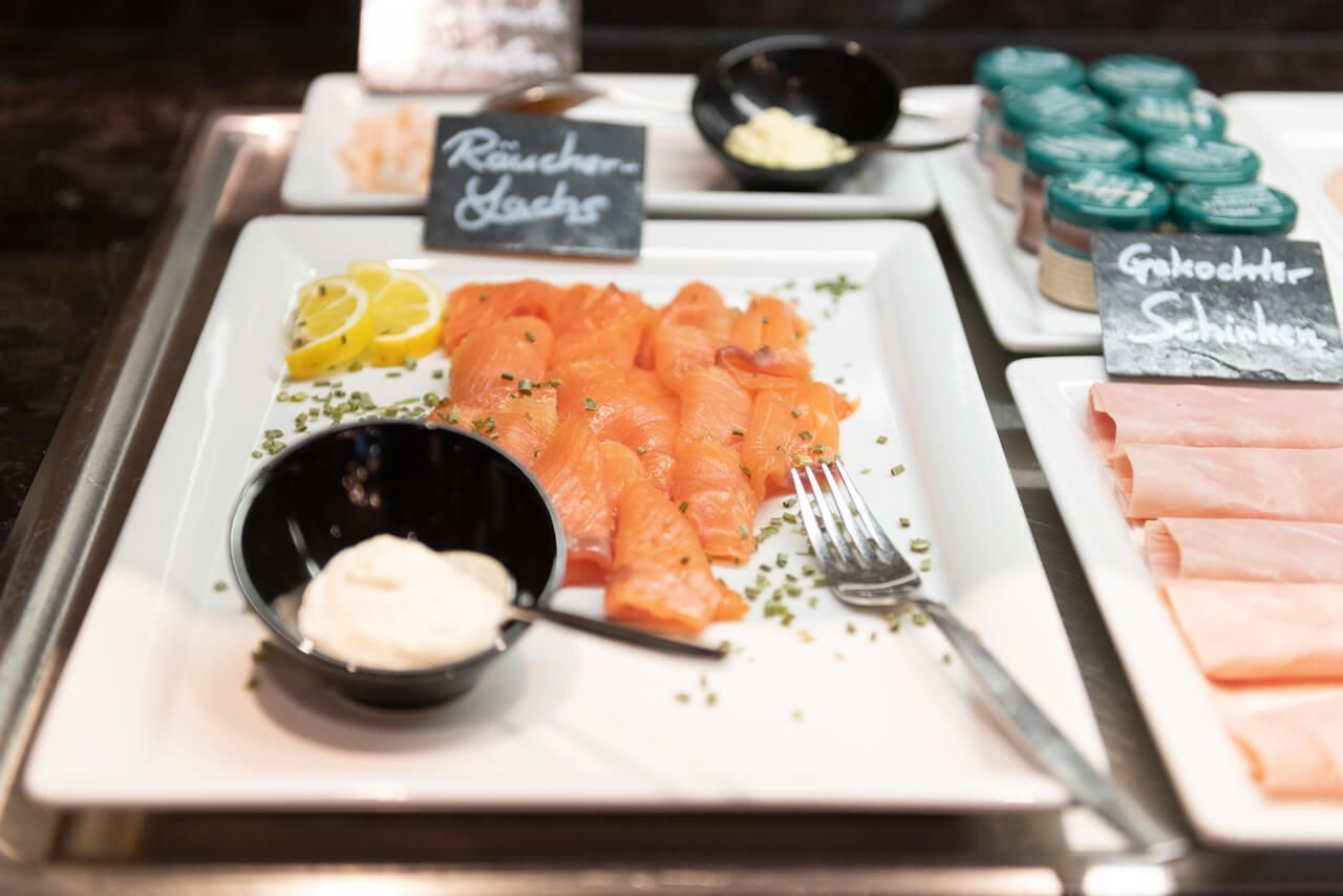 Buffetplatte mit geschnittenem Lachs, Räucherfisch, Gewürzen und Servierbesteck zum Frühstück-Alzey.