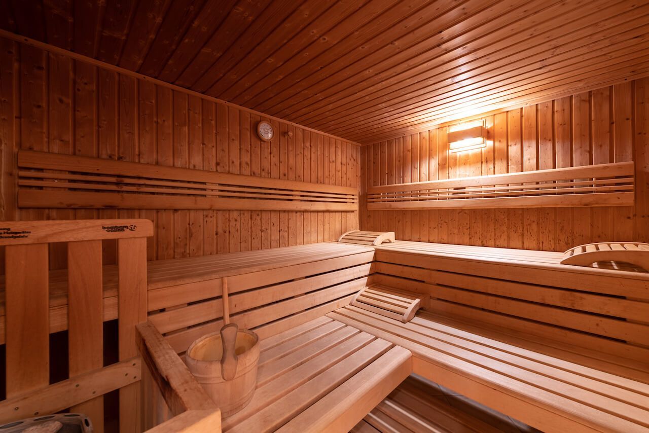 Leeres Saunainterieur aus Holz mit Lattenbänken und warmem orangefarbenem Licht im SPA bei Rheinhessen.