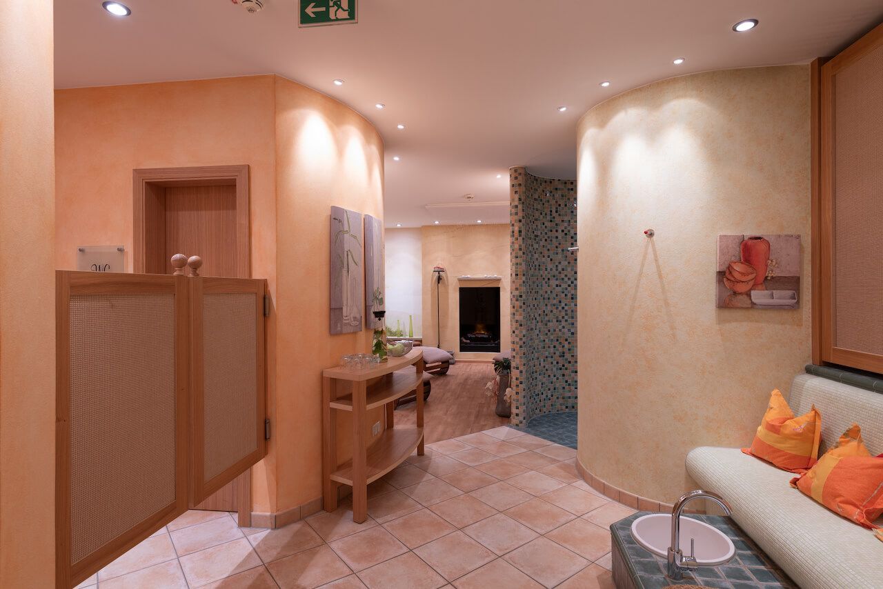 Warmfarbige Wellness-Oase im ART-Hotel BRaun, Sofas, gemustertem Fliesenboden und Deckeneinbauleuchten.