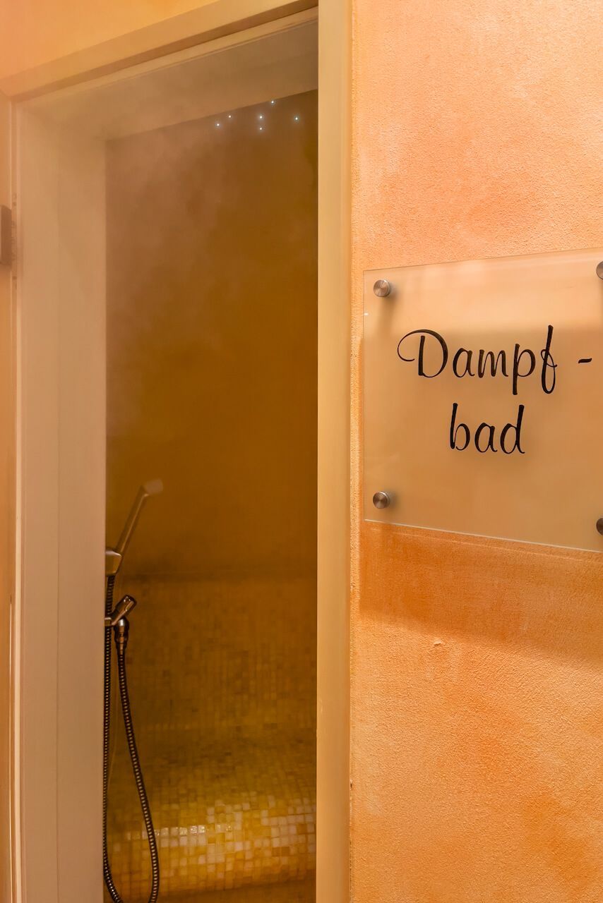 Dampfbadtür mit Glasscheibe und Schild mit der Aufschrift „Dampfbad“ in der Wellness-Oase Kirchheimbolanden.