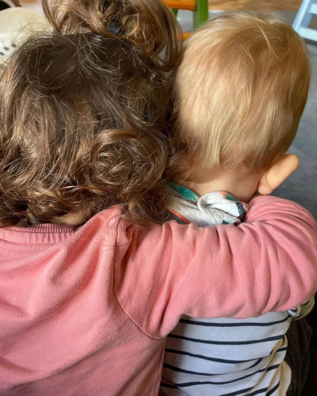 Ein Mädchen und ein Baby umarmen sich.