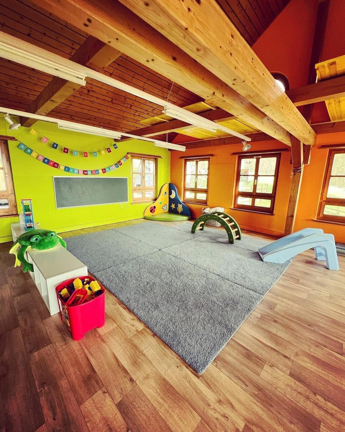 Ein großer Raum mit vielen Spielsachen und einer Rutsche.