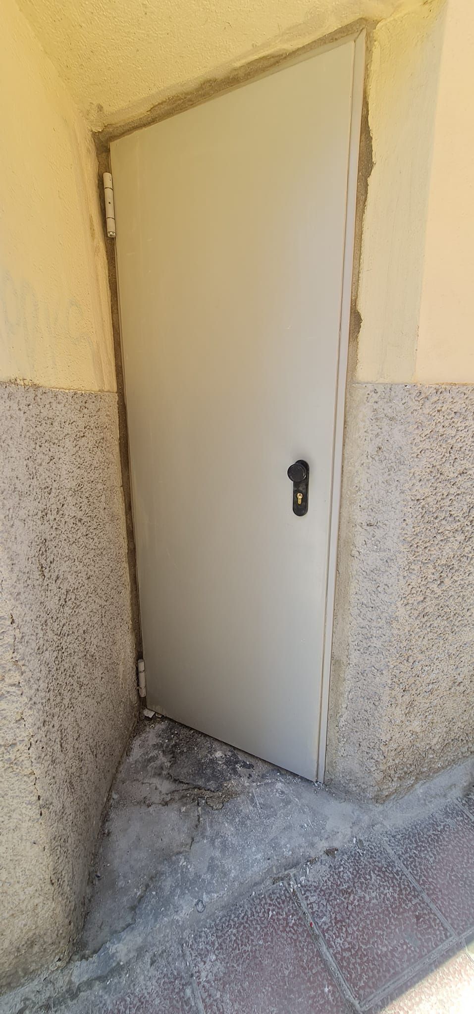 Una puerta blanca está en la esquina de un edificio.