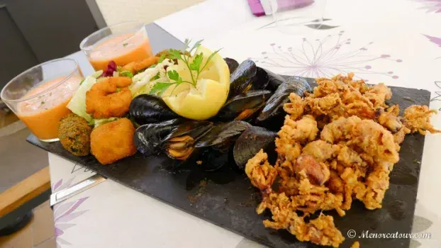 Un plato de espaguetis con salsa de tomate y caviar encima.