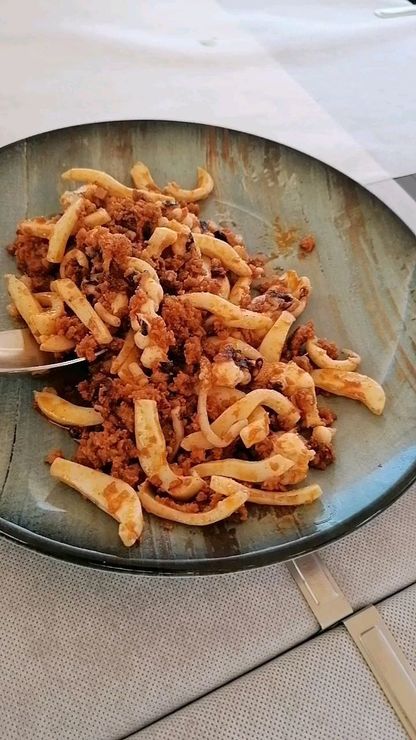 Una persona sostiene una bandeja de cucharas llenas de comida.
