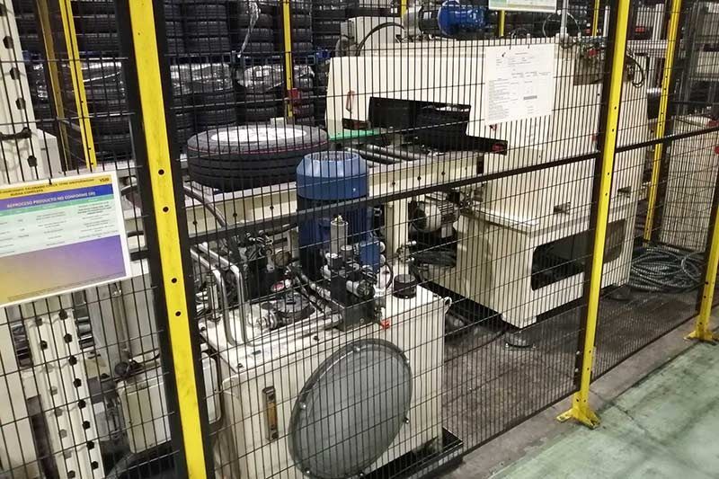 Una máquina está detrás de una valla en una fábrica.