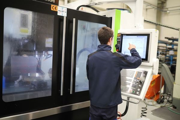 Un hombre está trabajando en una máquina en una fábrica.