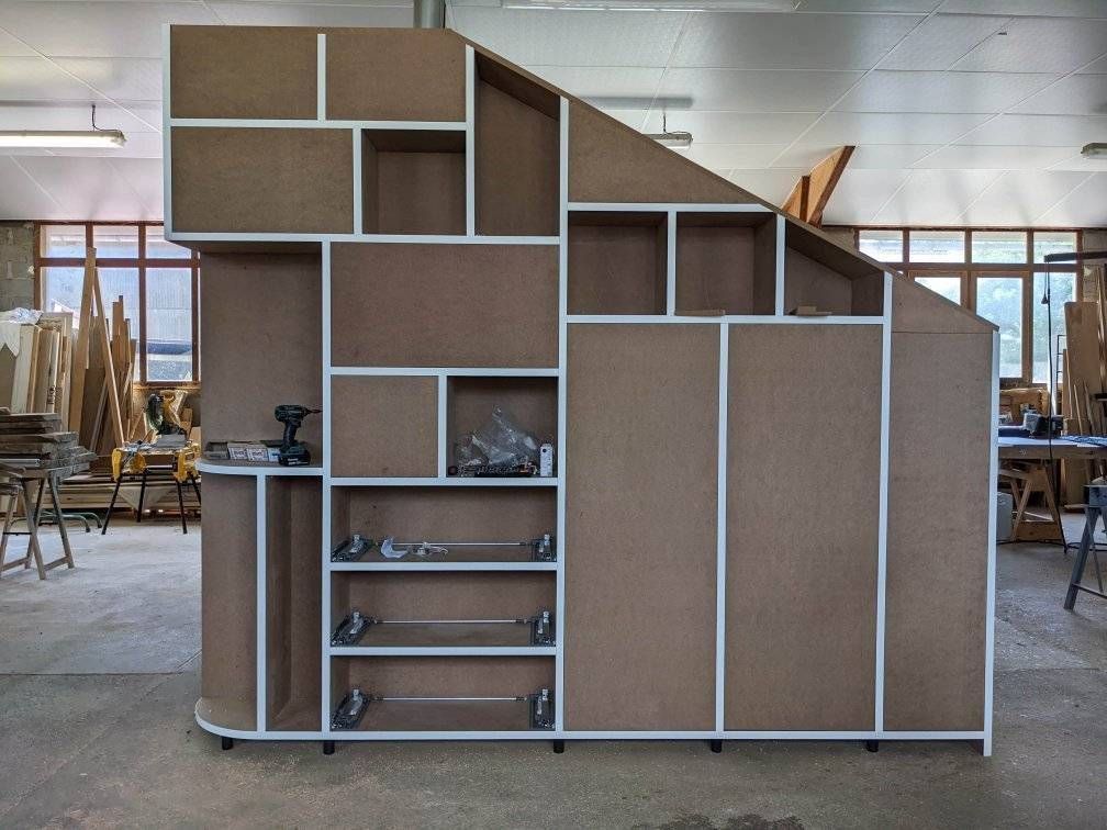 Étagère en bois à compartiments géométriques dans un atelier ou un studio.
