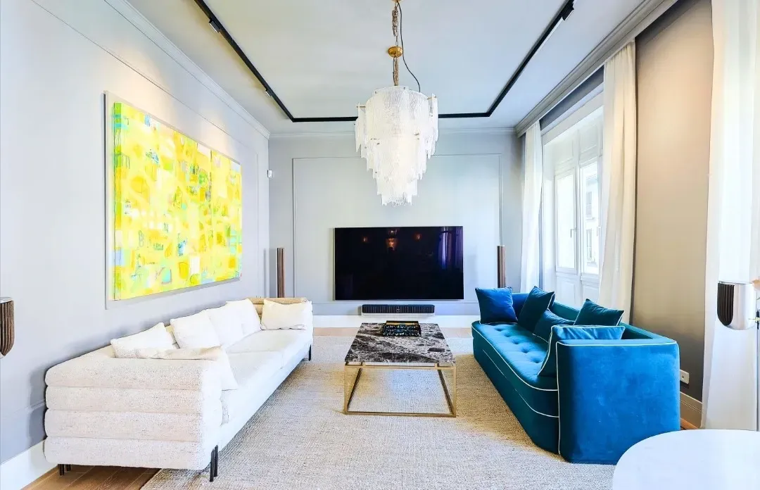 Una sala de estar con un sofá blanco, un sofá de terciopelo