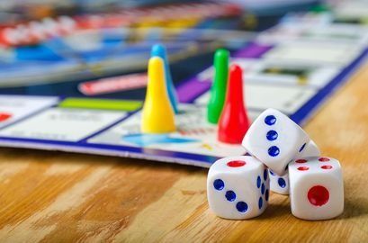 Un primer plano de un juego de mesa con dados y fichas sobre una mesa de madera.