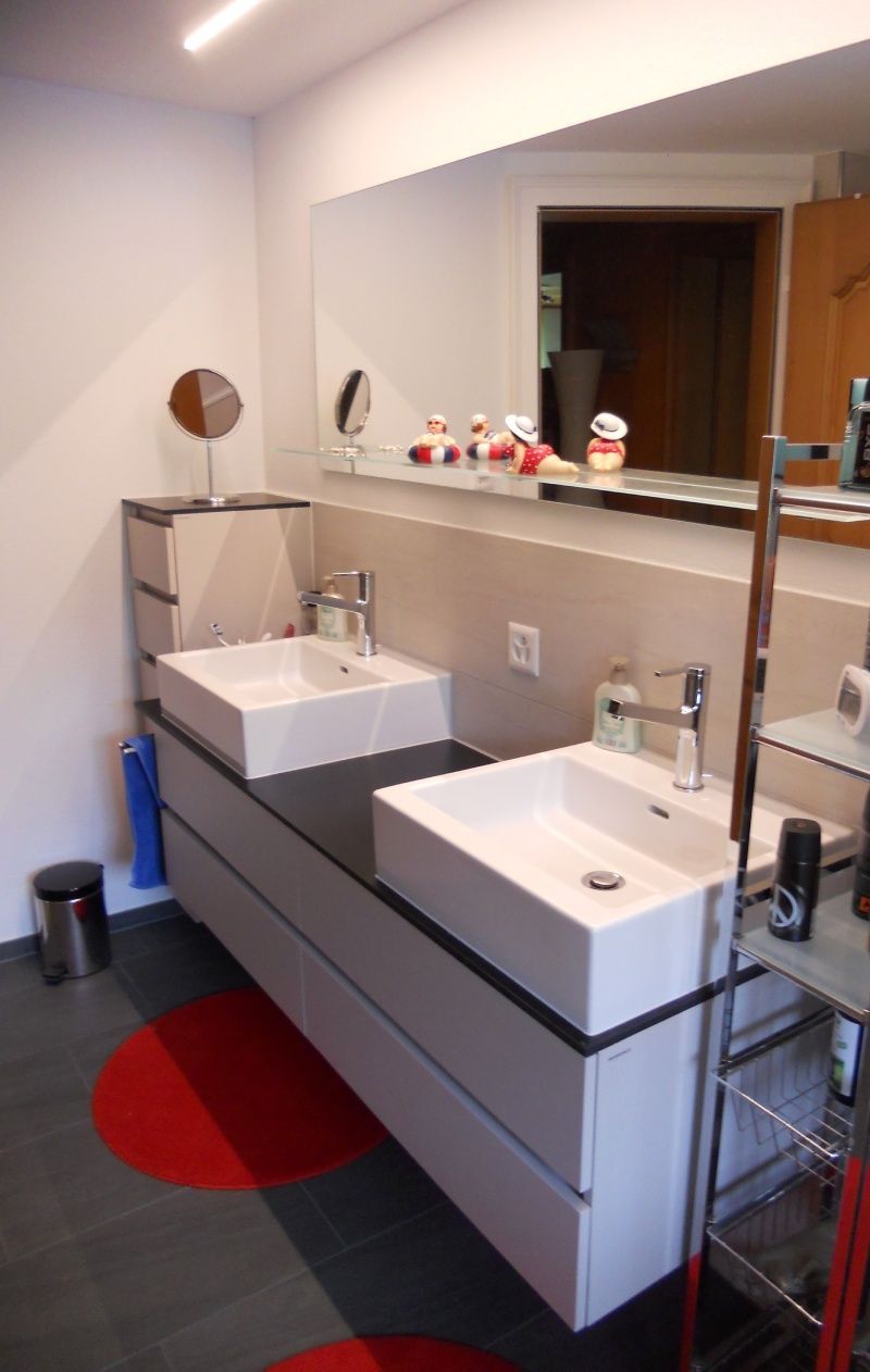 Badezimmer mit zwei getrennten Waschbecken und einem großen Spiegel