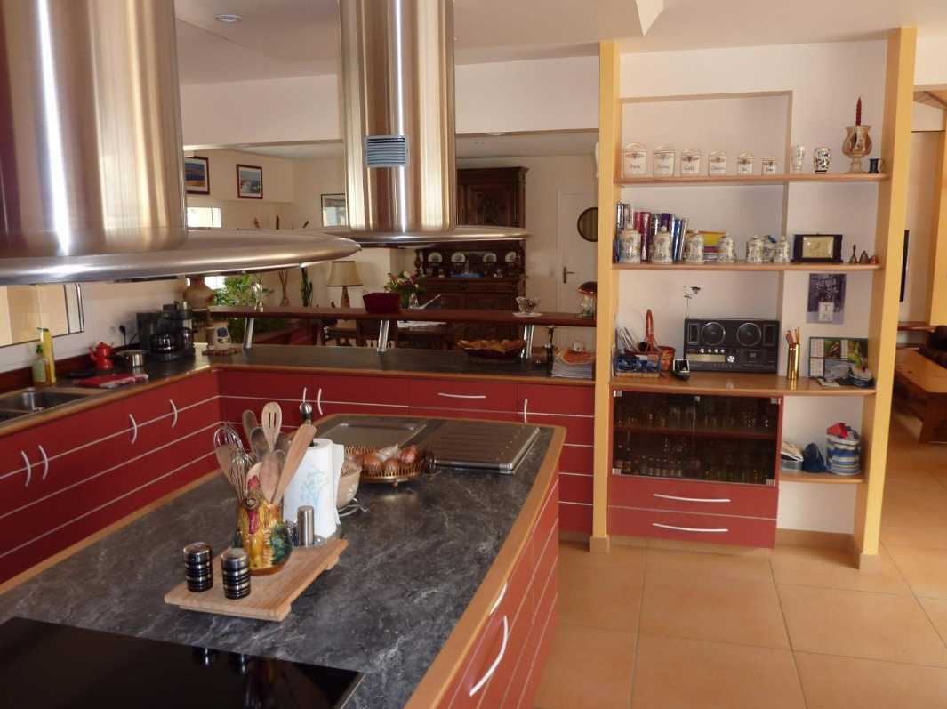 Cuisine moderne avec des placards rouges, des appareils électroménagers et un îlot.