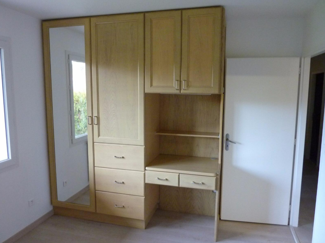 Armoire encastrée en bois avec tiroirs, étagères et miroir.