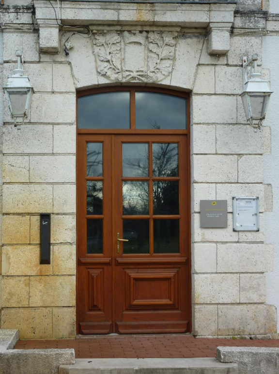 Une porte d'entrée vitrée, vue de l'extérieur.