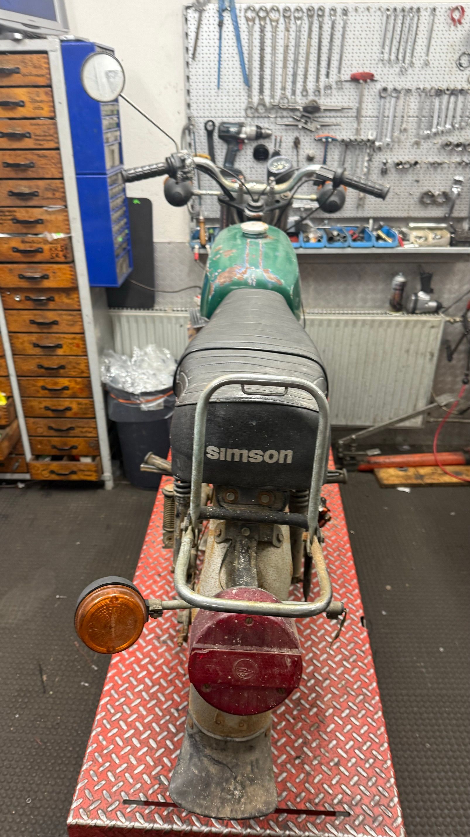 Orangefarbene Spielzeugautos in den Regalen eines Ladens, daneben ein rot-schwarzes Kinderauto.