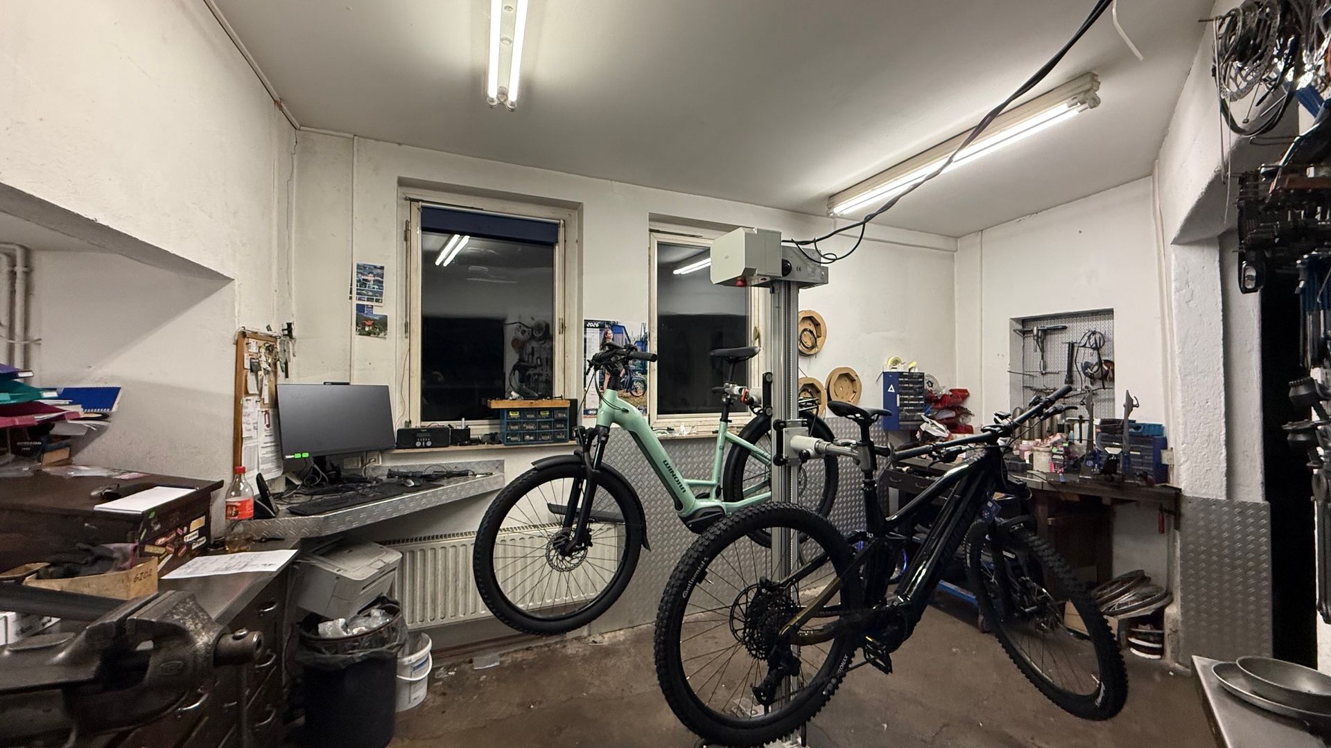 Motorrad-Ausstellungsraum mit Helmen in Regalen und einem blauen Motorrad im Vordergrund