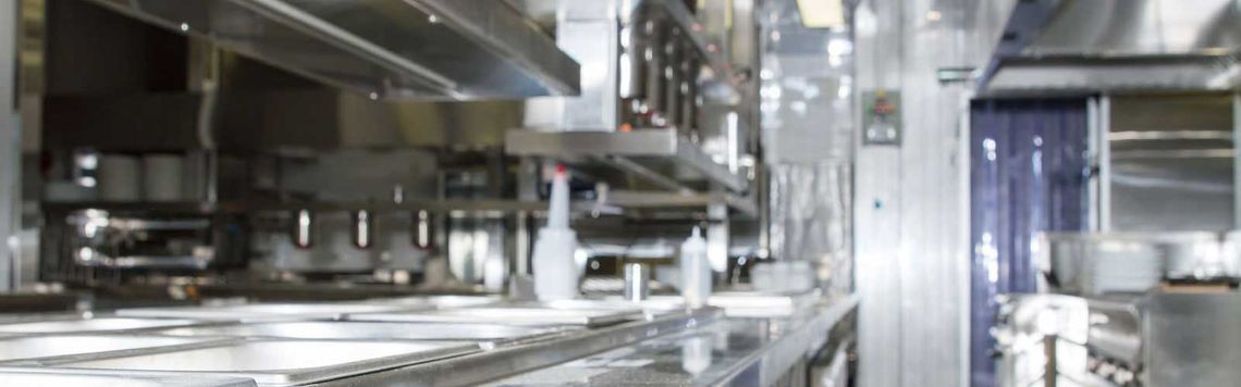 Una imagen borrosa de una cocina con muchos electrodomésticos de acero inoxidable.