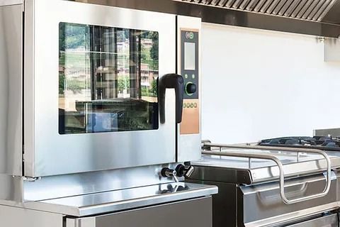 Un horno de acero inoxidable está colocado encima de una encimera en una cocina.
