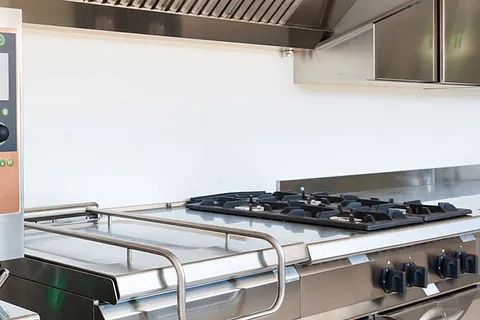 Un horno de acero inoxidable está colocado encima de una encimera en una cocina.
