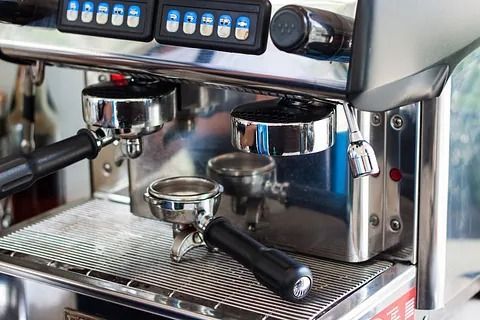 Un primer plano de una máquina de café con mango negro.
