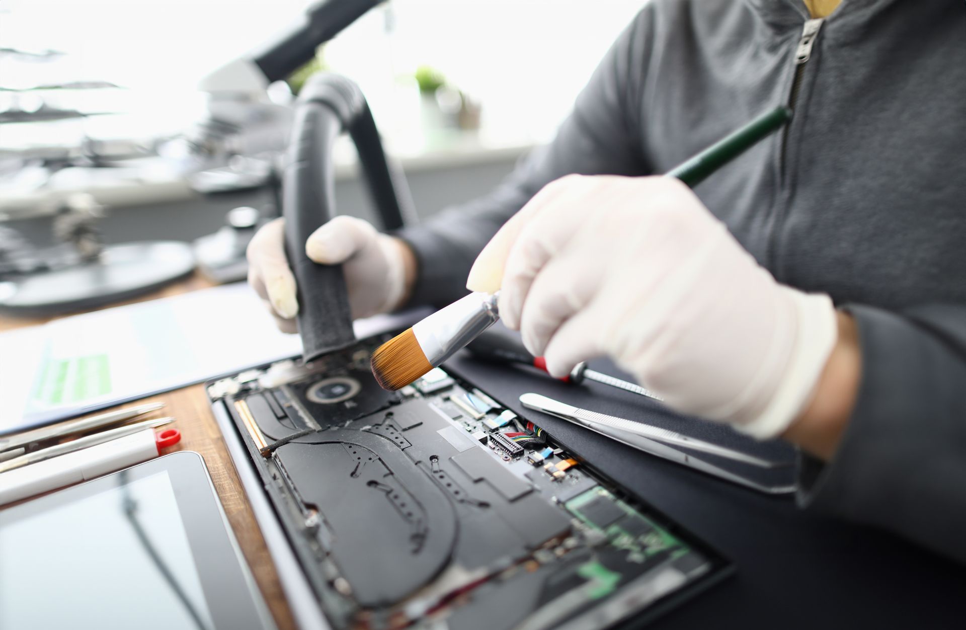Une personne nettoie un ordinateur portable démonté