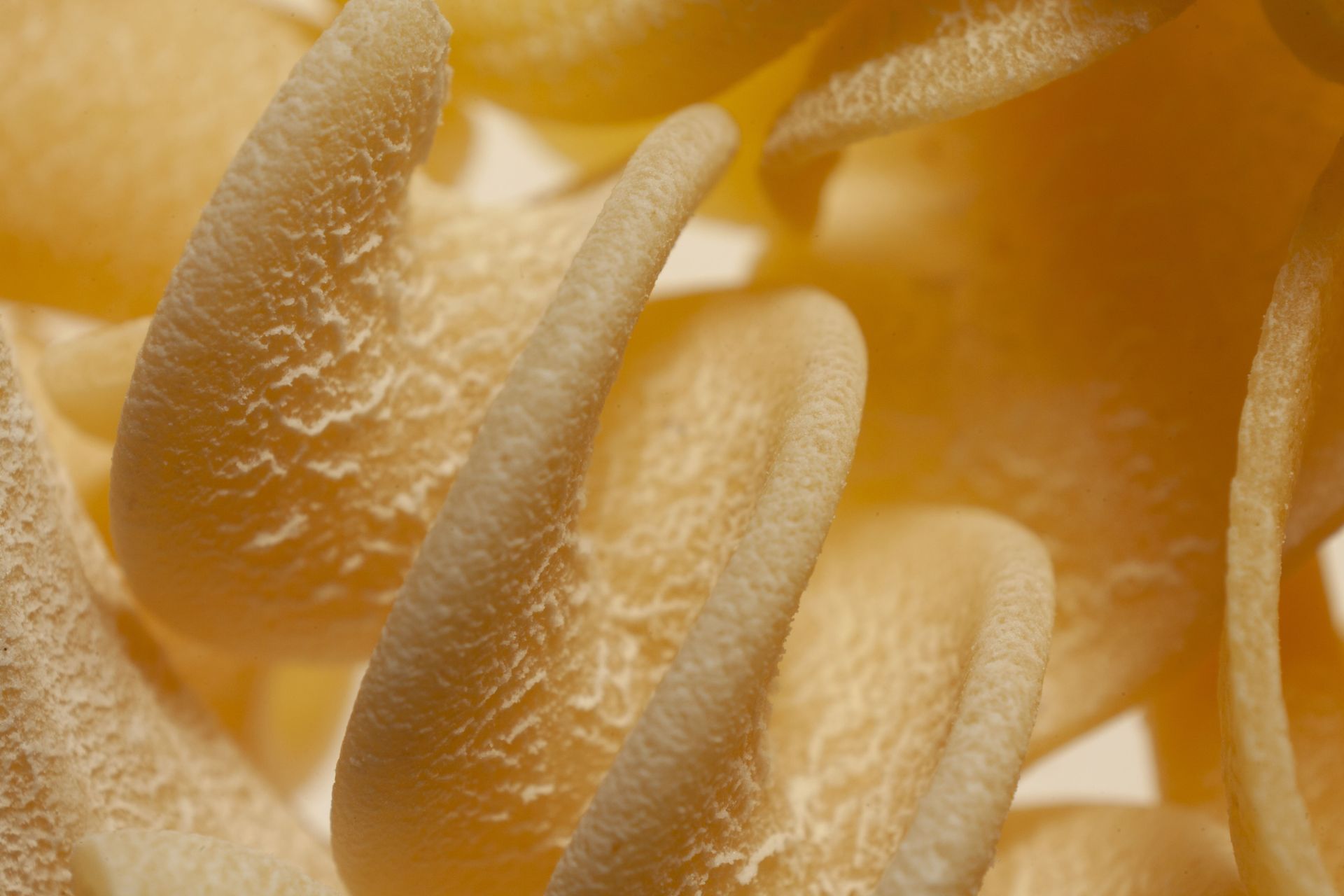 Un primer plano de una pila de pasta sobre una superficie blanca.