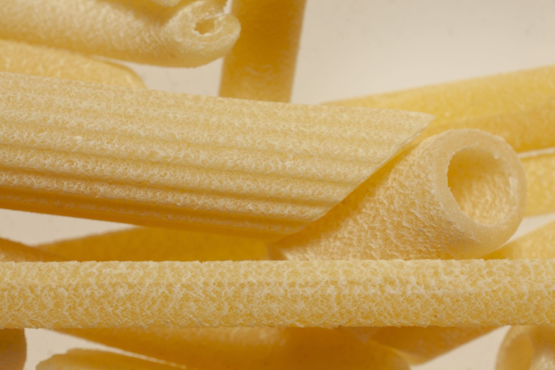 Un primer plano de una pila de pasta sobre una superficie blanca.