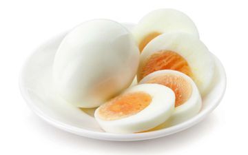 Huevos cocidos en rodajas con yemas de color naranja brillante sobre un plato blanco.