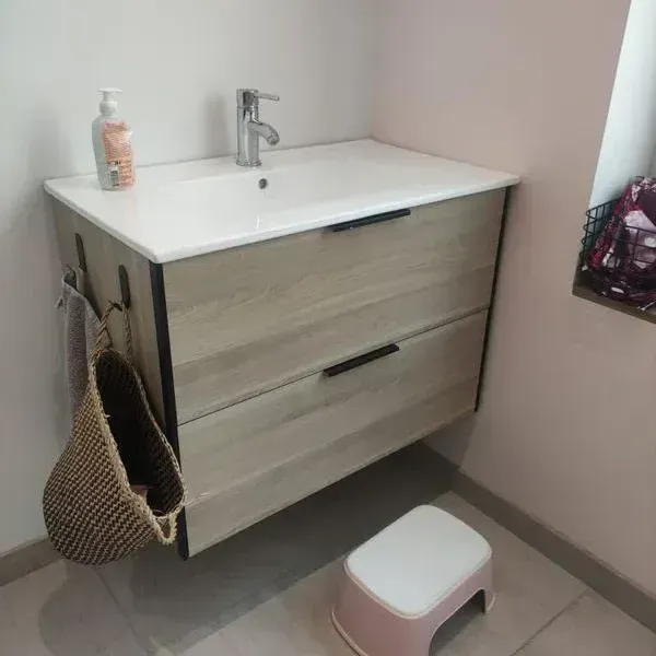 Un lavabo sur un meuble avec des tirroirs dans une salle de bains