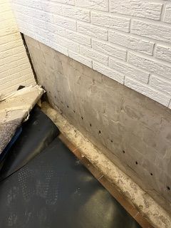 Eine Ziegelwand mit Löchern wird renoviert.