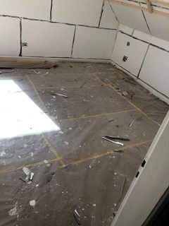 Ein Raum mit viel Müll auf dem Boden und den Wänden.