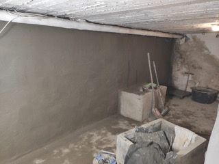 Ein Raum mit einer Betonwand und einem Besen darin.