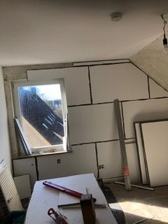 Ein Raum mit einem Fenster und einem Tisch mit Werkzeug darauf.