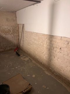 Ein Raum mit einer Ziegelwand und einer weißen Wand.