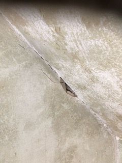 Eine Nahaufnahme einer Betonwand mit einem Loch darin.