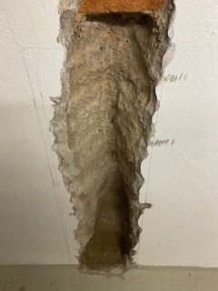 Ein Loch in einer Wand mit einem Ziegelstein darin.