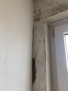 Eine Nahaufnahme einer weißen Wand neben einem Fenster.