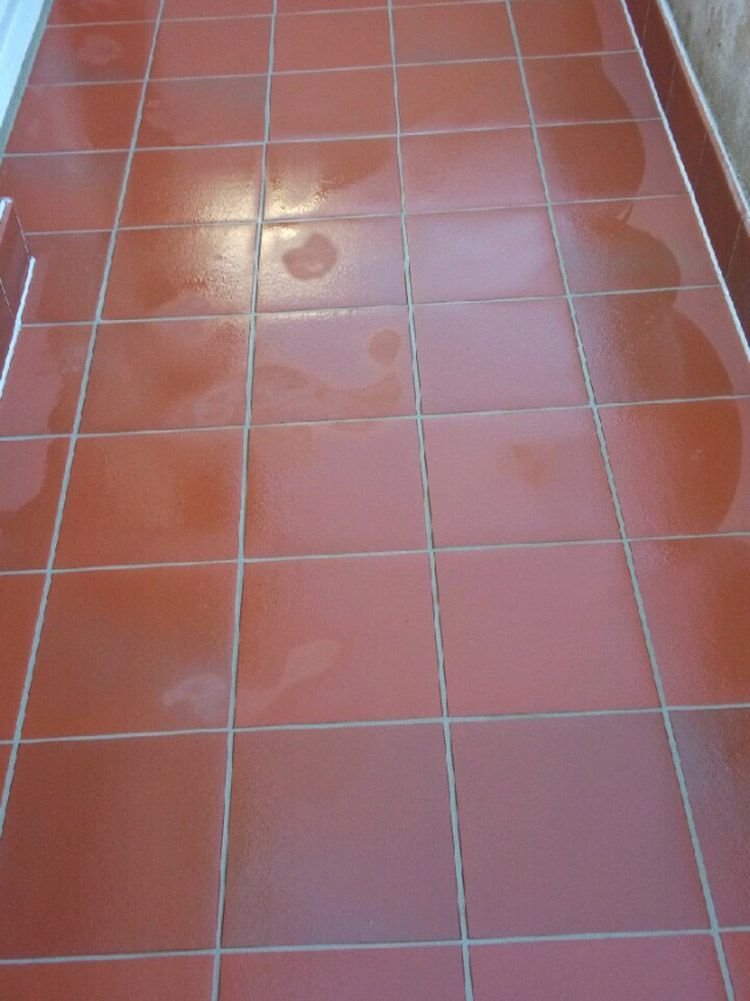 Ein roter Fliesenboden mit weißem Rand