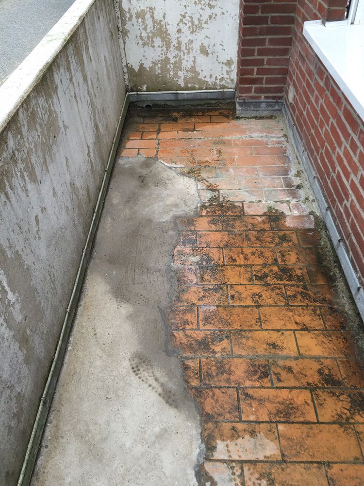 Ein schmutziger Ziegelweg neben einer Ziegelmauer.