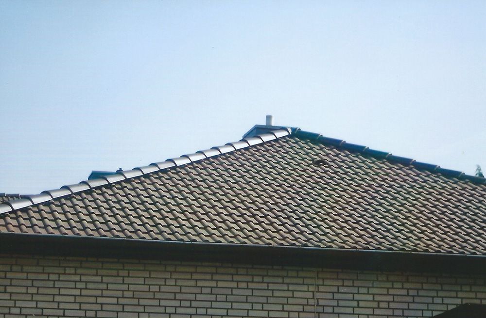 Ein Backsteingebäude mit Ziegeldach und blauem Himmel im Hintergrund