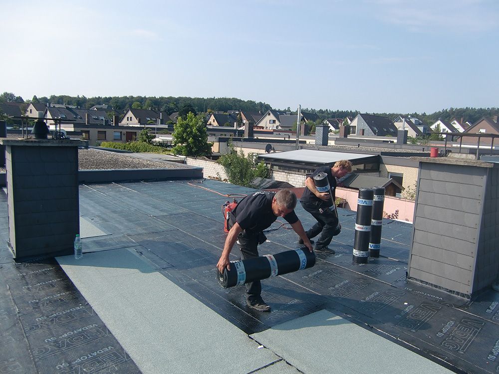 Zwei Männer arbeiten auf dem Dach eines Gebäudes