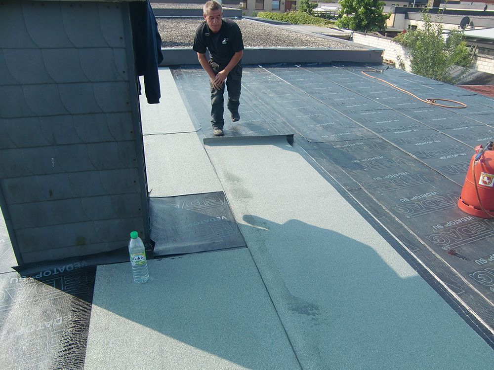 Ein Mann steht auf einem Dach neben einer Flasche