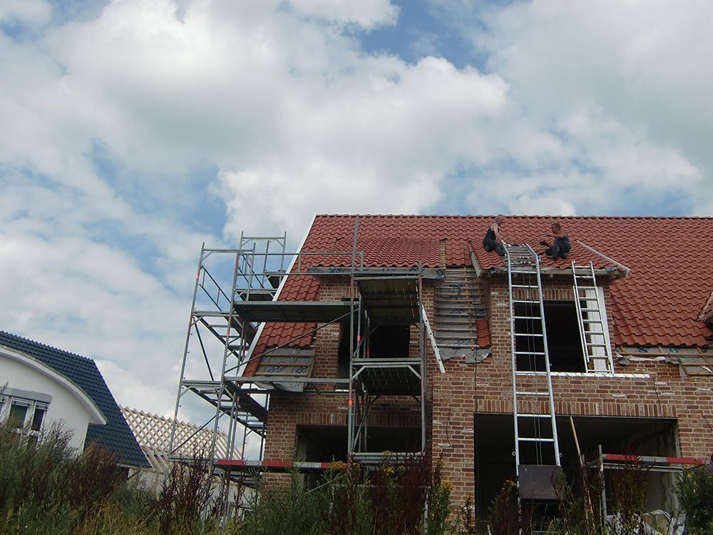Ein im Bau befindliches Backsteinhaus mit Gerüst darum herum