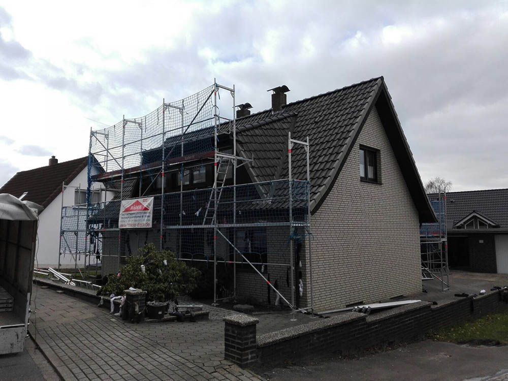 Ein Haus wird umgebaut und ist von einem Gerüst umgeben.