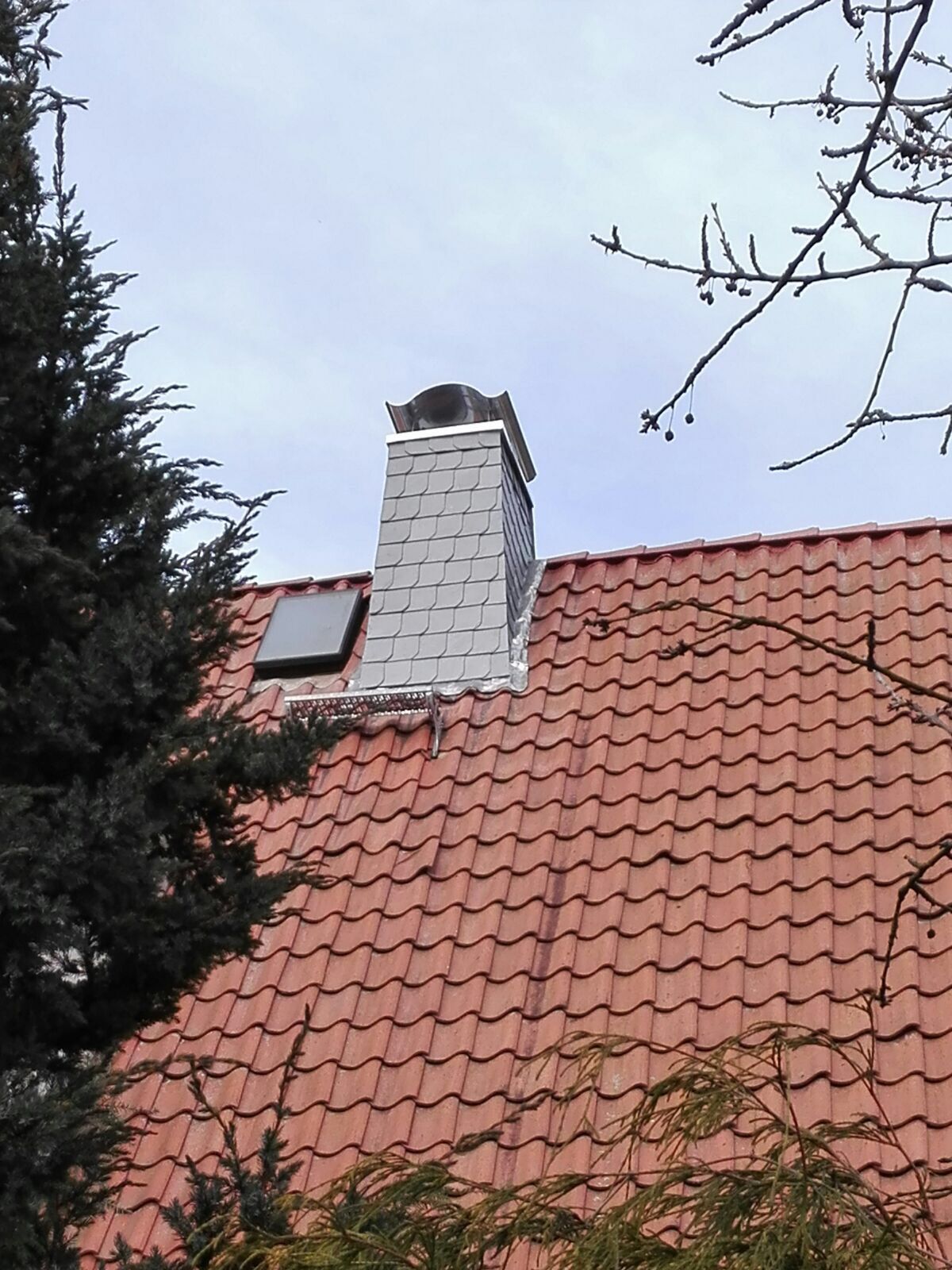 Ein rotes Ziegeldach mit einem Schornstein darauf