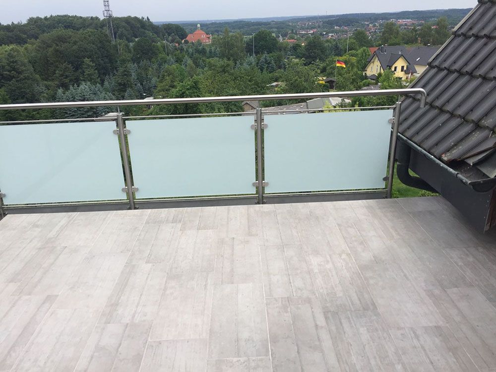 Ein Balkon mit Edelstahlgeländer und Blick auf die Stadt
