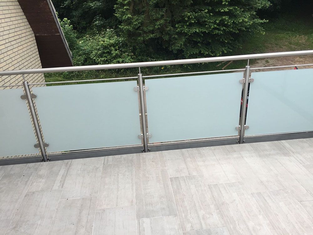 Ein Balkon mit Edelstahlgeländer und Milchglas
