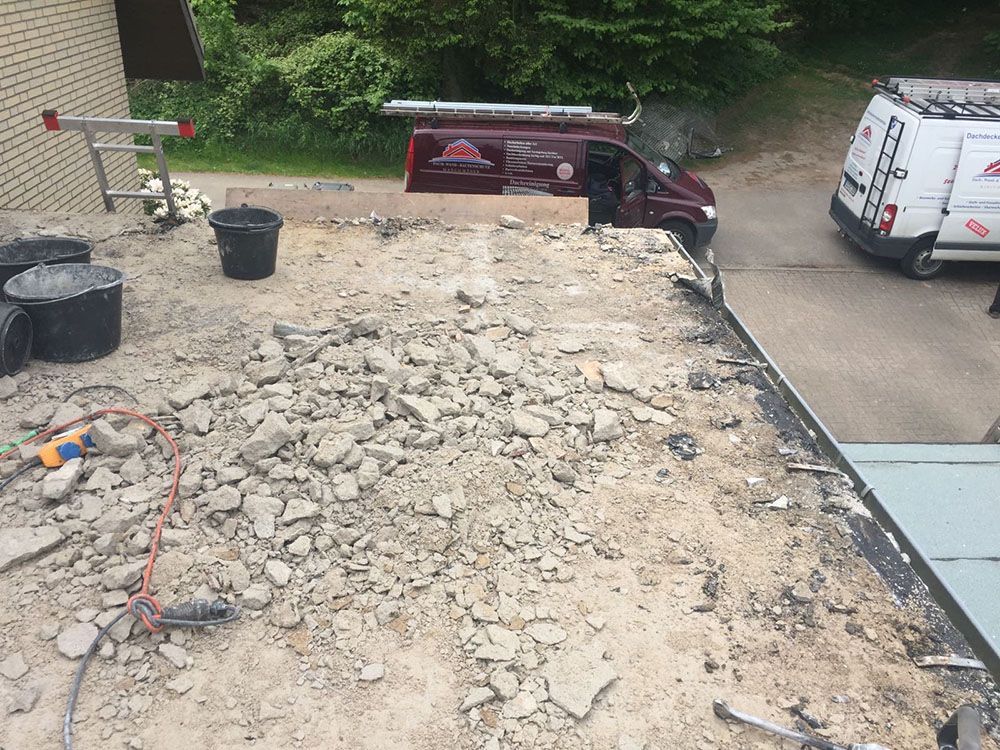 Ein Lieferwagen ist am Straßenrand neben einem Steinhaufen geparkt.