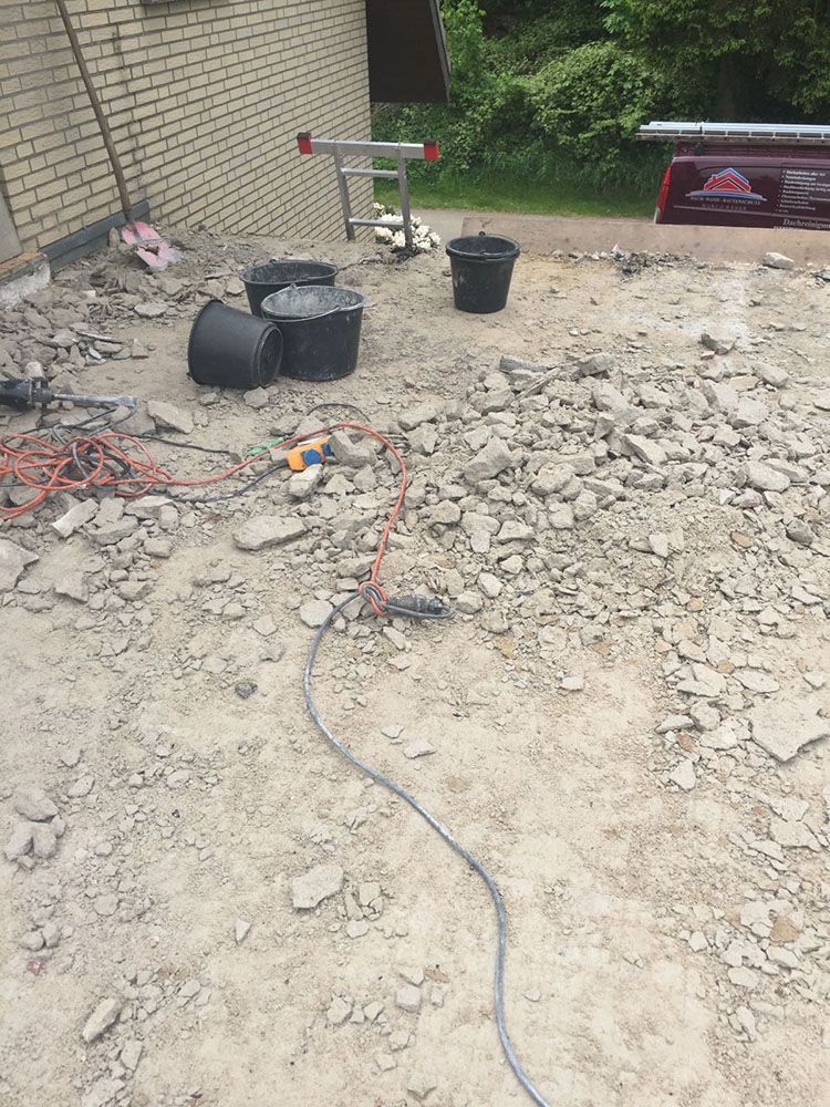 Neben einem Steinhaufen steht eine Leiter auf dem Boden.